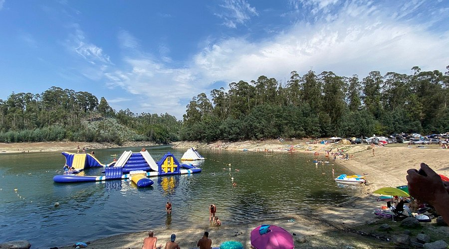 Praia fluvial do Ermal em dia de verão, com estruturas insufláveis na água